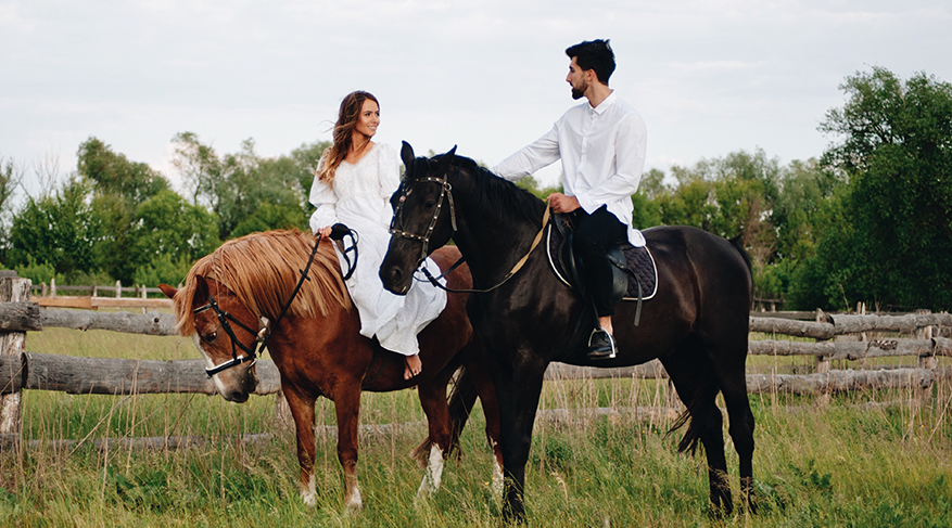 A couple doing horseback riding on a date