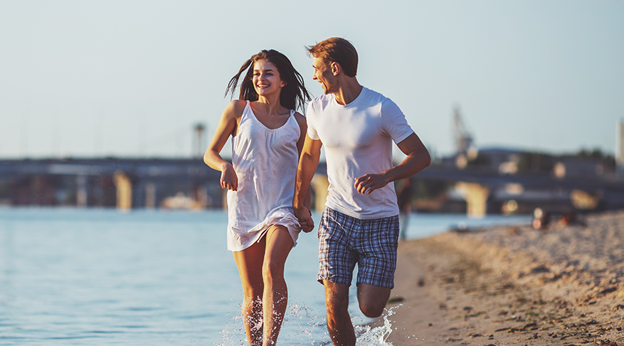 young couple running through the beach